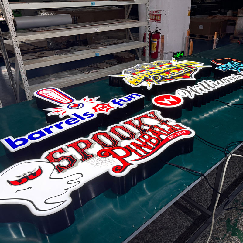 Factory batch production of custom LED acrylic signs including American Pinball, Williams, Barrels of Fun, and Spooky Pinball